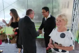 Spotkanie towarzyskie z uśmiechami i wręczaniem kwiatów.