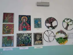 Wystawa prac plastycznych z mozaikami i obrazami przedstawiającymi naturę oraz postacie.