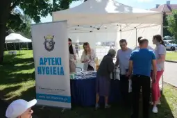 Stoiska promocyjne Apteki Hygienia z ludźmi w trakcie wydarzenia plenerowego.