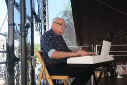 Mężczyzna gra na keyboardzie podczas występu na scenie.