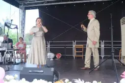 Dwoje wykonawców śpiewa na scenie podczas występu artystycznego.