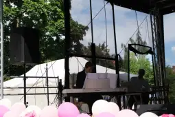 Muzyk grający na pianinie na scenie z dekoracjami w tle.