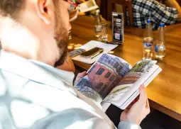 Mężczyzna przegląda album z fotografiami budynków.