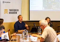 Spotkanie w Twierdzy Kraków z uczestnikami dyskusji przy stole.