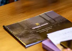 Publikacja o Twierdzy Kraków na stole, obok telefon i notatki.