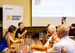 Spotkanie dyskusyjne w sali konferencyjnej z uczestnikami i prelegentką.