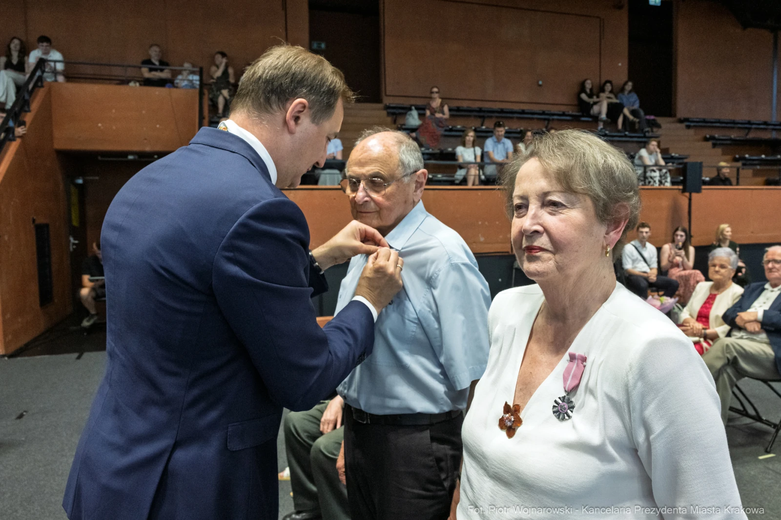 Wręczenie odznaczenia mężczyźnie przez urzędnika w obecności kobiety i innych gości.  Autor: Piotr Wojnarowski