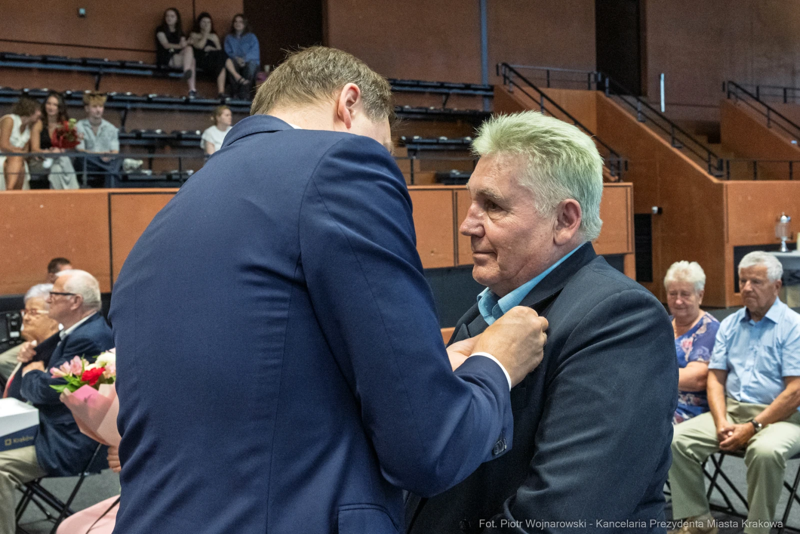 Mężczyzna odbiera odznaczenie podczas uroczystości w sali.  Autor: Piotr Wojnarowski