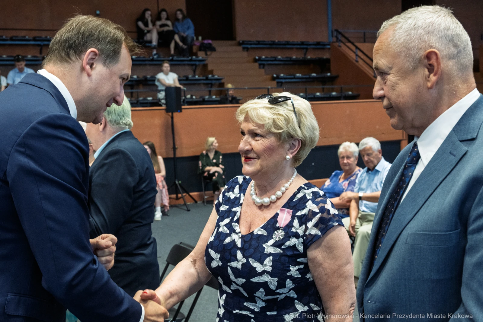 Spotkanie dwóch osób, uściski dłoni, w tle widoczni uczestnicy wydarzenia.  Autor: Piotr Wojnarowski