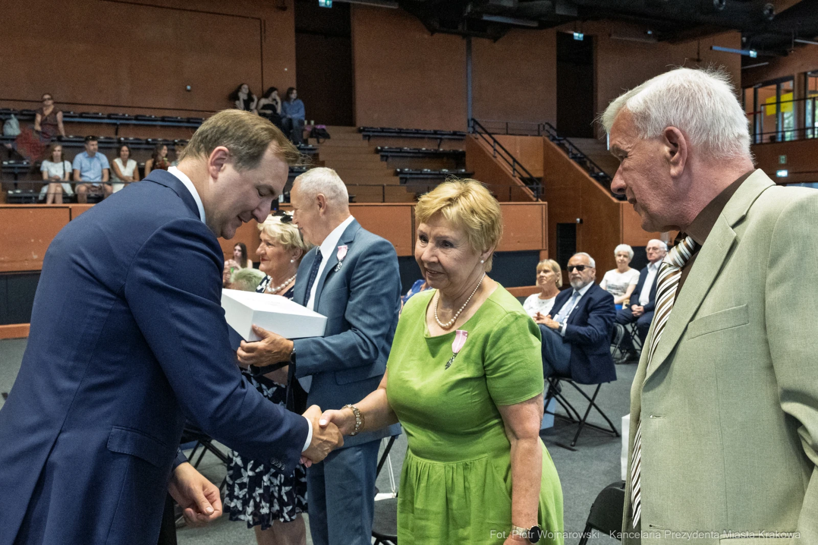 Uroczystość wręczenia nagród, ludzie w formalnych strojach, uściski dłoni.  Autor: Piotr Wojnarowski