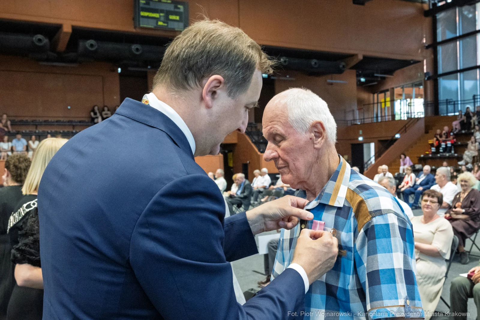 Wręczenie odznaczenia mężczyźnie podczas uroczystości w sali.  Autor: Piotr Wojnarowski