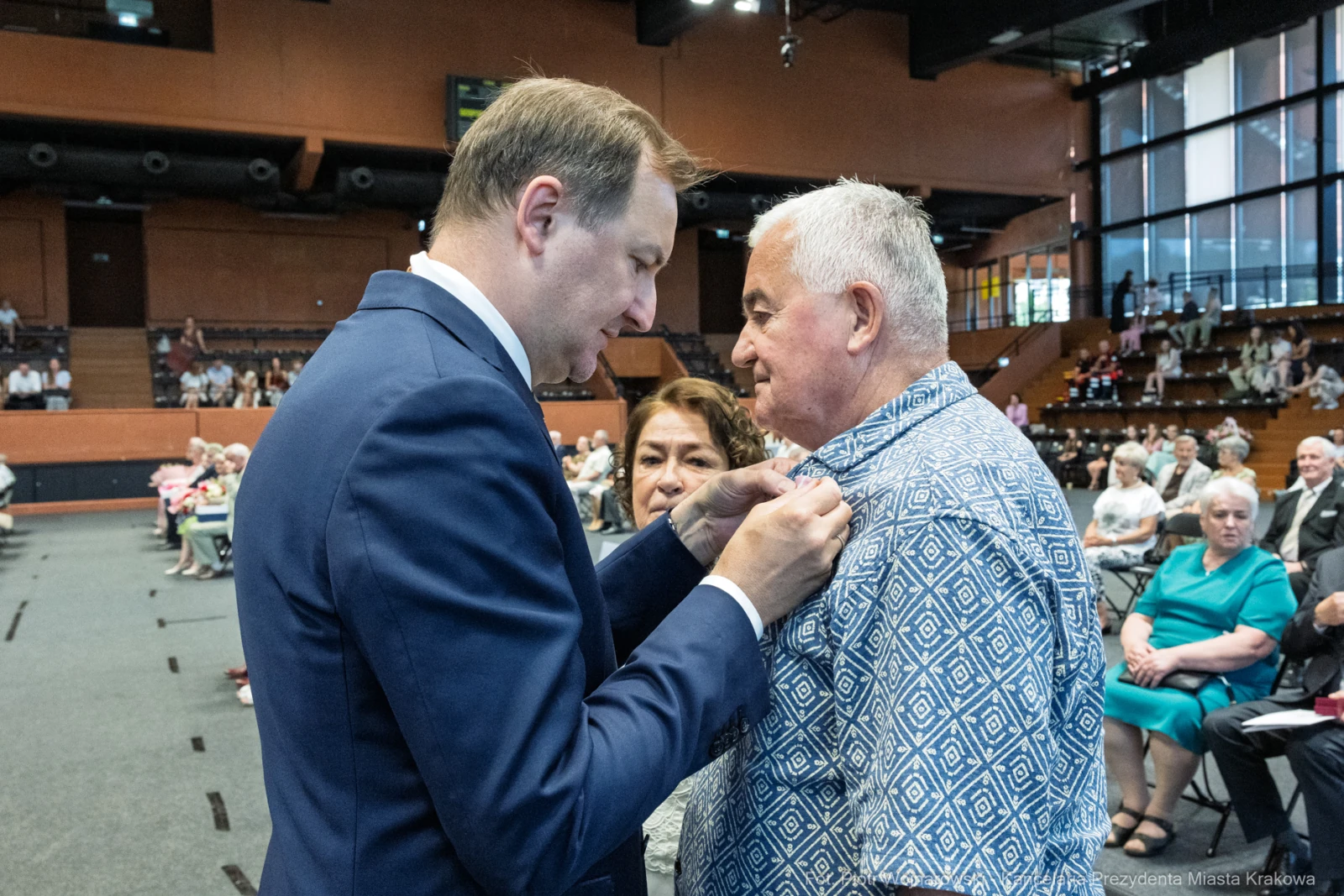 Wręczenie odznaczenia mężczyźnie przez urzędnika w obecności kobiety.  Autor: Piotr Wojnarowski