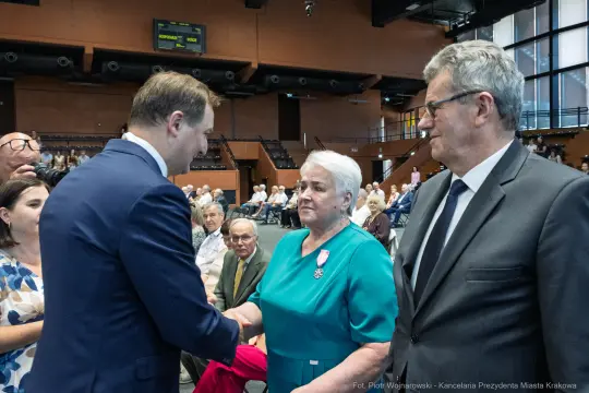 Uroczystość wręczenia odznaczeń, gratulacje i uściski dłoni.