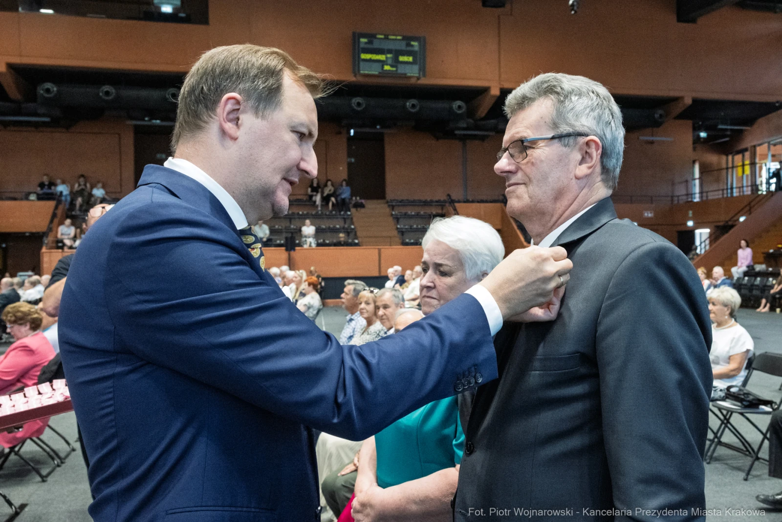 Uroczystość wręczenia odznaczeń, mężczyzna przypina medal innemu mężczyźnie.  Autor: Piotr Wojnarowski