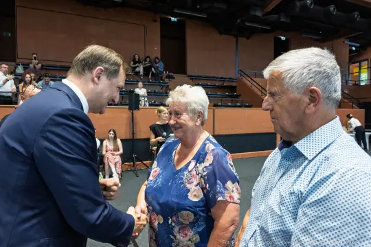 Spotkanie mężczyzny z dwiema starszymi osobami w sali.