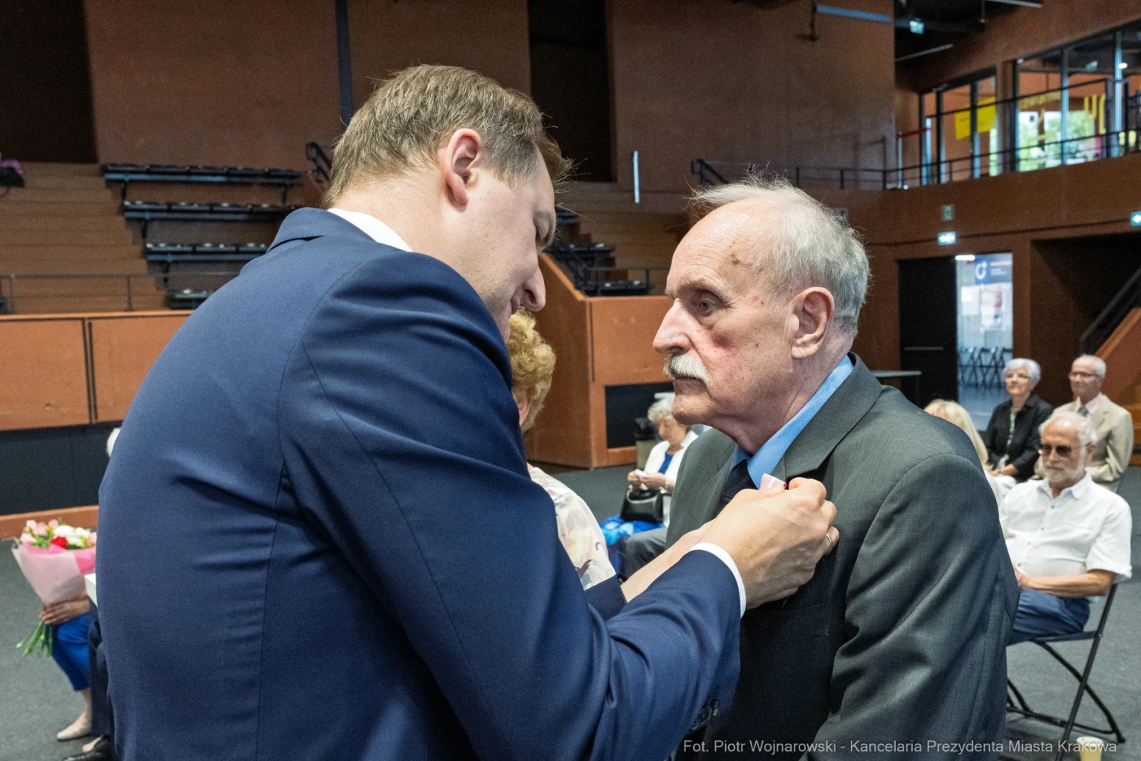 Wręczenie odznaczenia mężczyźnie w garniturze podczas uroczystości.  Autor: Piotr Wojnarowski