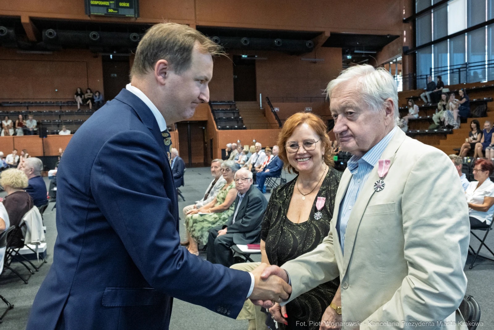 Uroczystość wręczenia odznaczeń, uściski dłoni i uśmiechy uczestników.  Autor: Piotr Wojnarowski