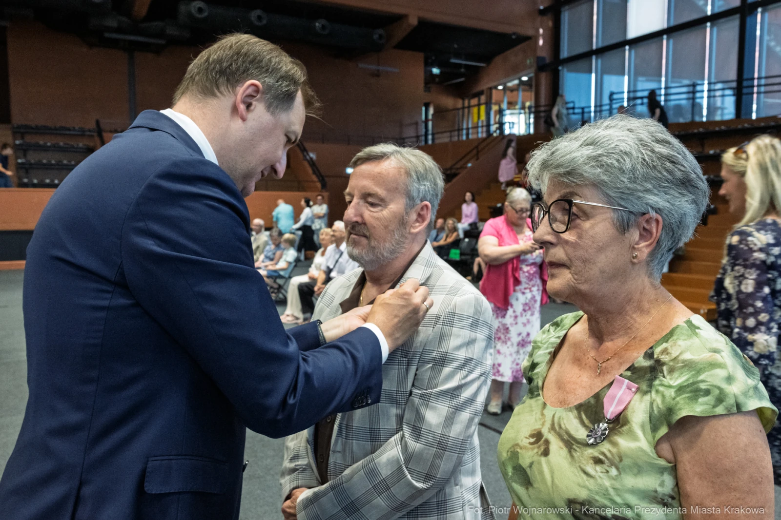 Uroczystość wręczenia odznaczeń, mężczyzna przypina medal do marynarki innego mężczyzny.  Autor: Piotr Wojnarowski