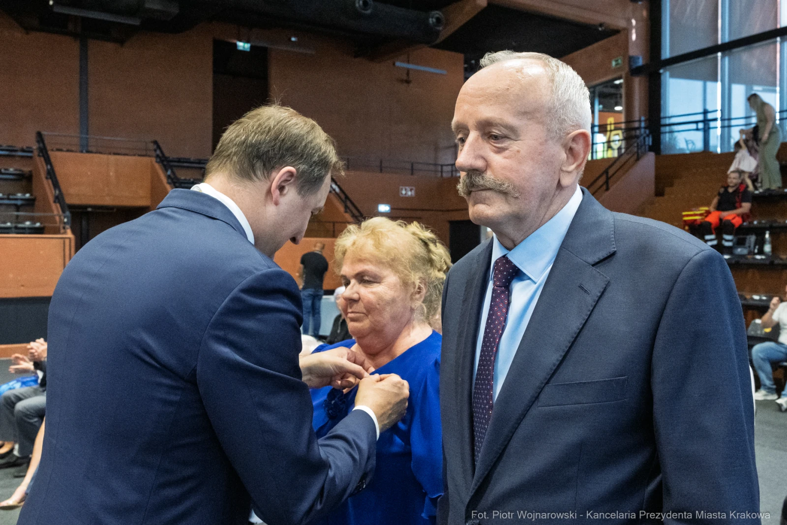 Wręczenie odznaczenia przez mężczyznę kobiecie, obok stoi mężczyzna w garniturze.  Autor: Piotr Wojnarowski
