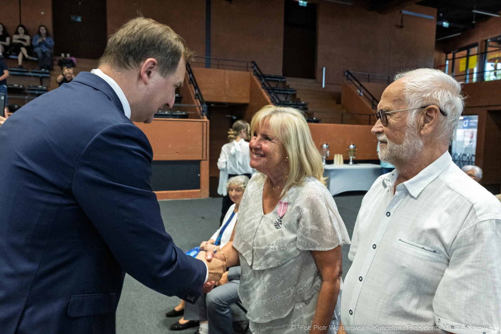 Uroczystość wręczenia odznaczeń, uściski dłoni i uśmiechy uczestników.  Autor: Piotr Wojnarowski