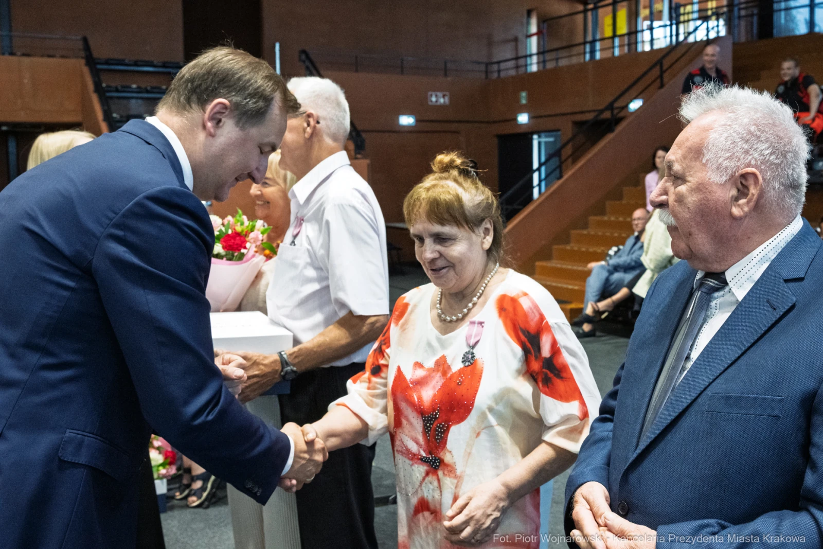 Uroczystość wręczenia nagród, uściski dłoni i kwiaty.  Autor: Piotr Wojnarowski