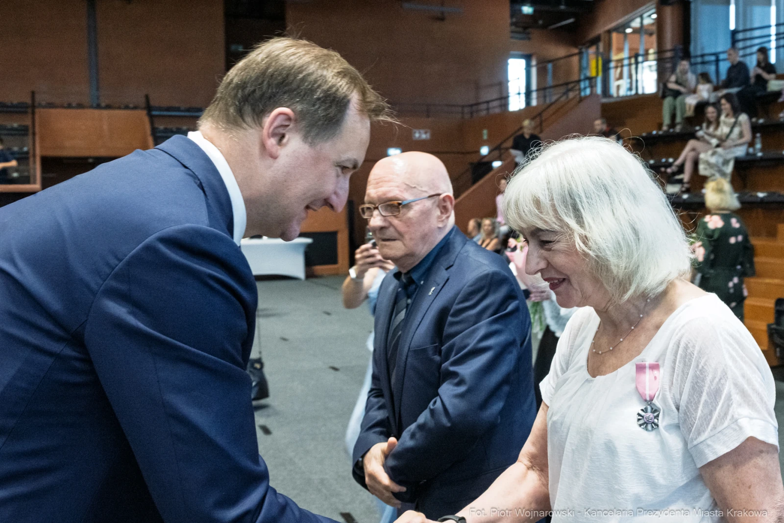 Wręczenie odznaczeń w trakcie uroczystości, uściski dłoni i uśmiechy uczestników.  Autor: Piotr Wojnarowski