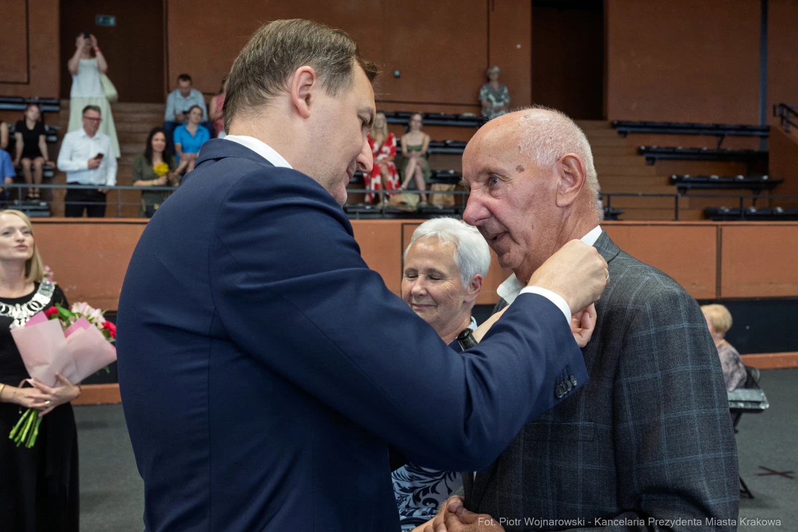 Wręczenie odznaczenia mężczyźnie przez urzędnika w obecności innych osób.  Autor: Piotr Wojnarowski