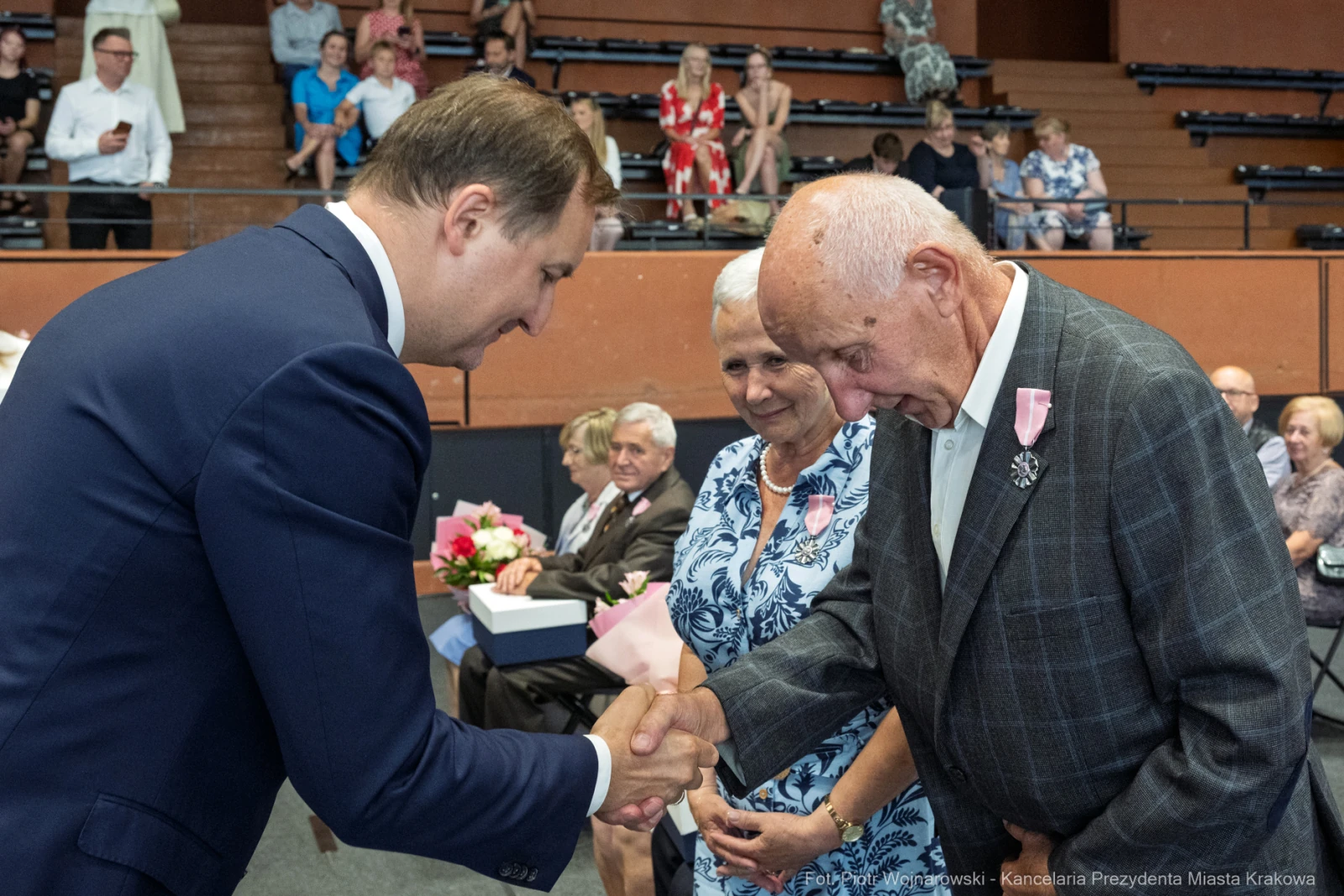 Uścisk dłoni między mężczyzną a starszym mężczyzną, w tle widoczni goście.  Autor: Piotr Wojnarowski