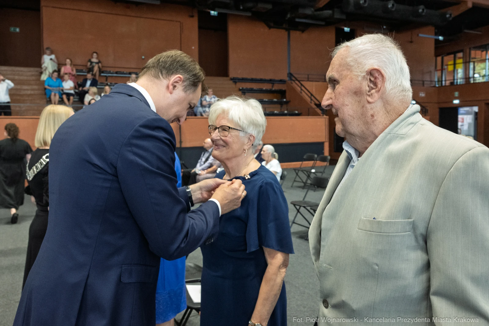 Uroczystość wręczenia odznaczeń, uśmiechnięte osoby w formalnych strojach.  Autor: Piotr Wojnarowski