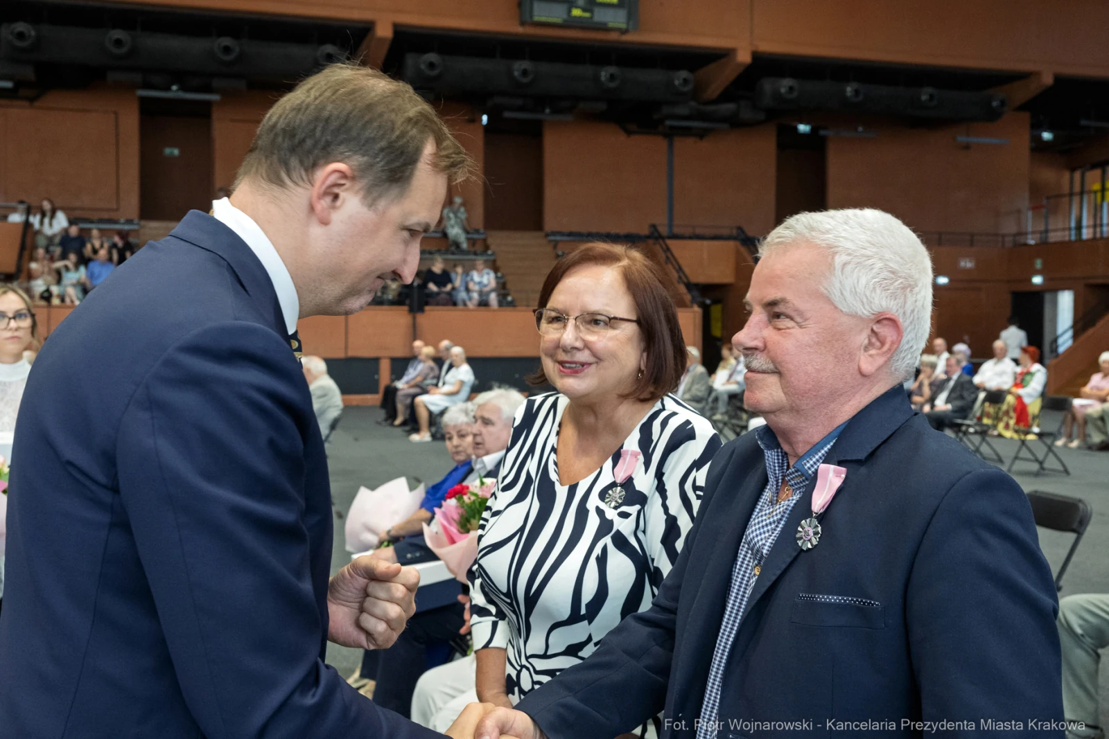 Uroczystość wręczenia nagród, uśmiechnięte twarze, gratulacje i kwiaty.  Autor: Piotr Wojnarowski