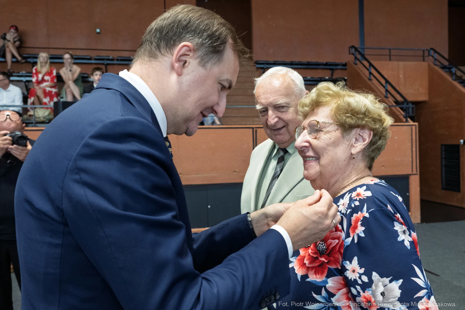 Uroczystość wręczenia odznaczenia starszej kobiecie przez mężczyznę w garniturze.  Autor: Piotr Wojnarowski