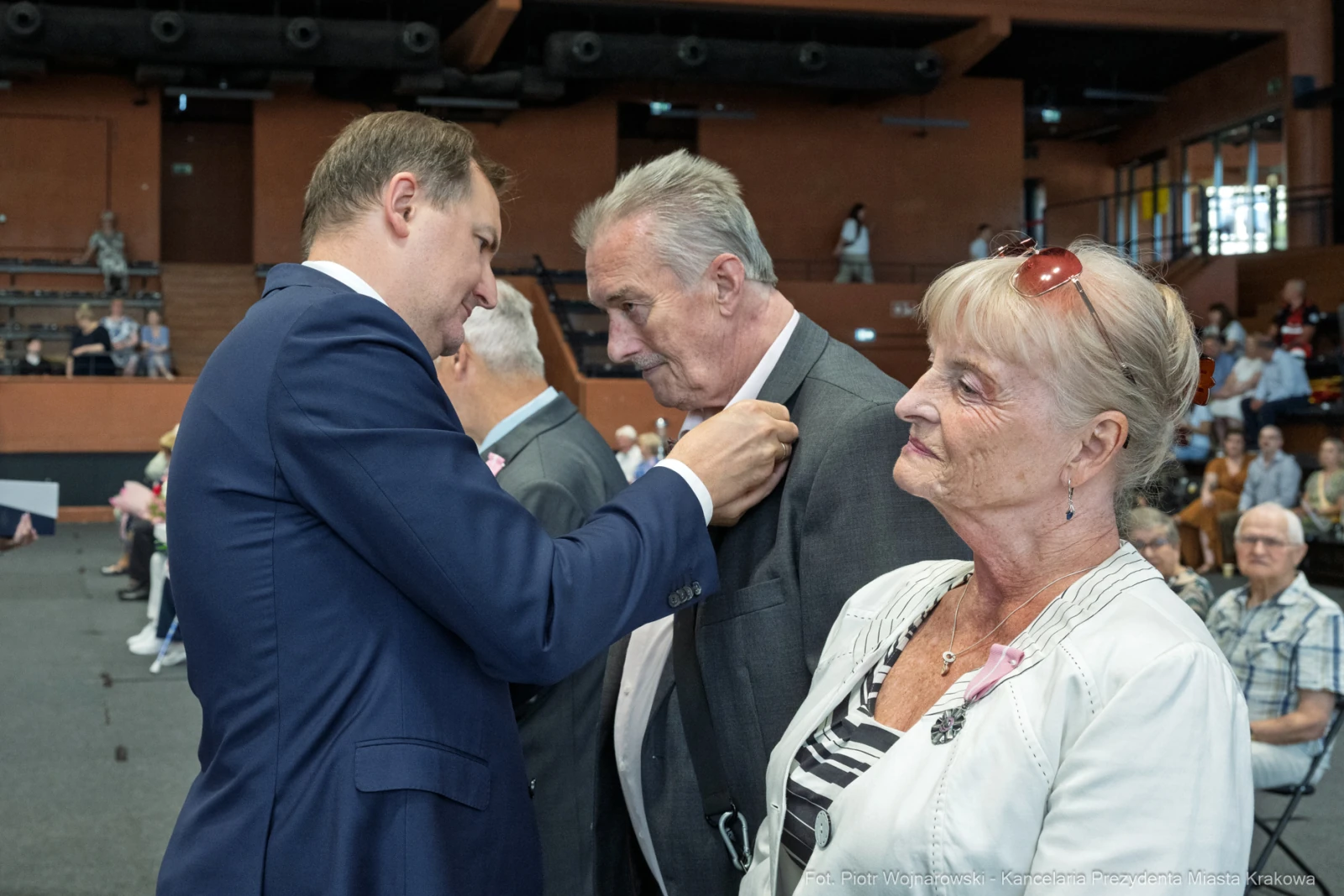 Uroczystość wręczenia odznaczeń, mężczyzna przypina medal do klapy marynarki innego mężczyzny.  Autor: Piotr Wojnarowski