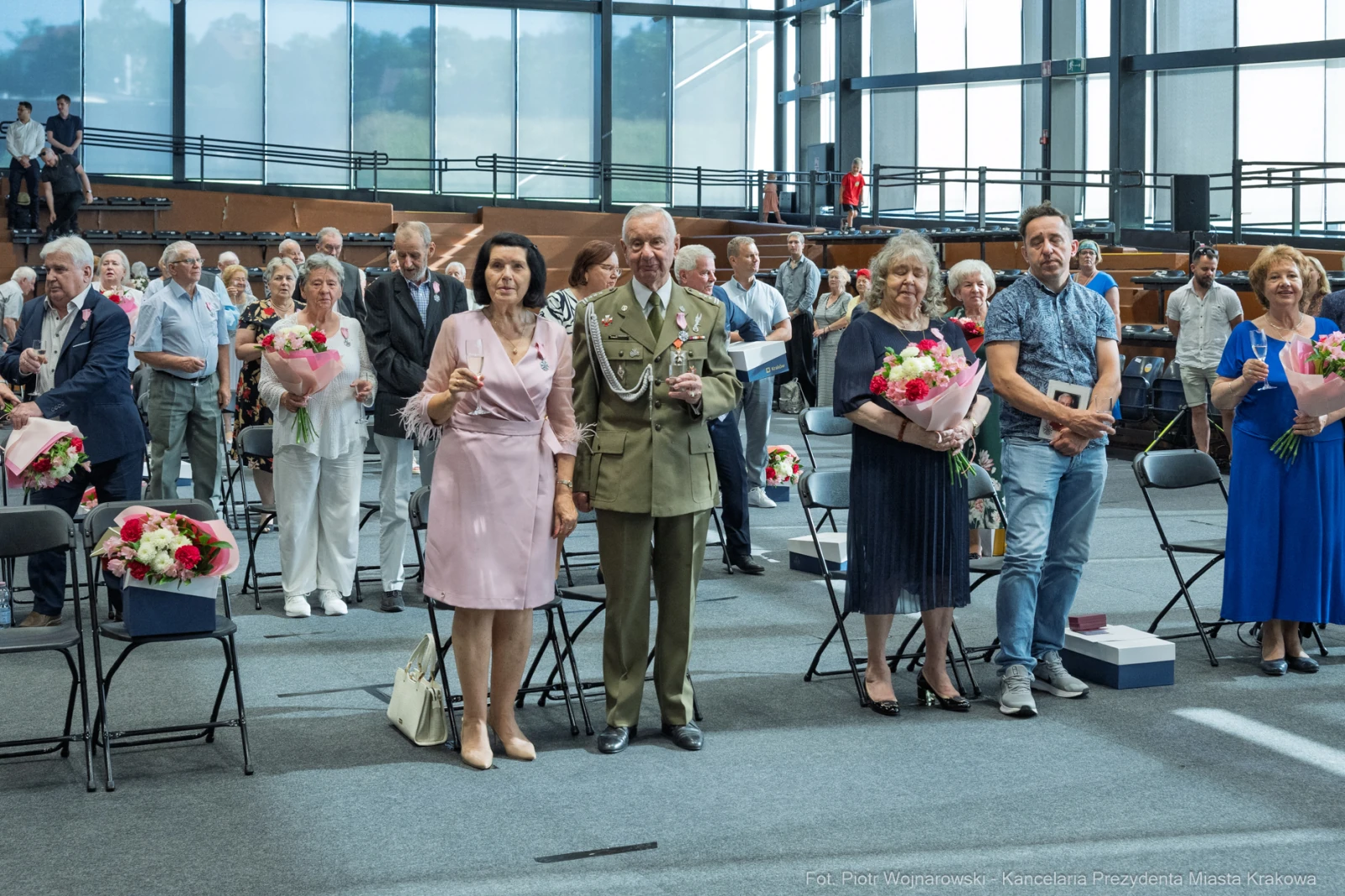 Uroczystość z udziałem osób w eleganckich strojach, trzymających kwiaty i nagrody.  Autor: Piotr Wojnarowski