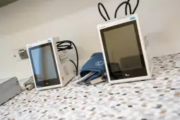 Dwa urządzenia medyczne do pomiaru ciśnienia krwi na stole.