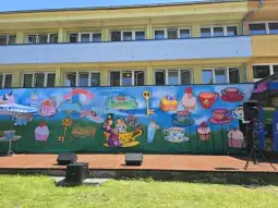 Fresk z kolorowymi ilustracjami filiżanek, ciast i kluczy na tle zieleni.