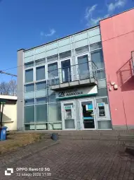 Budynek banku Credit Agricole z witrynami i bankomatami.