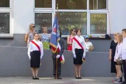 Uroczystość z pocztem sztandarowym i uczestnikami w strojach galowych.