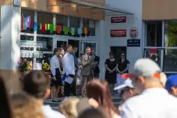 Uroczystość szkolna z przemówieniami i dekoracjami, uczestnicy w formalnych strojach.