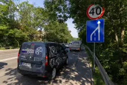 Samochód dostawczy z logo Authentic Cars na drodze obok znaku ograniczenia prędkości do 40 km/h.