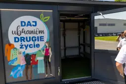 Mobilny punkt z odzieżą do ponownego wykorzystania z hasłem Daj ubraniom drugie życie.