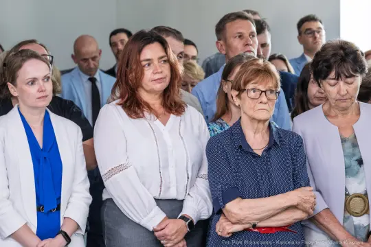 Grupa osób w skupieniu, słuchających przemówienia lub prezentacji.