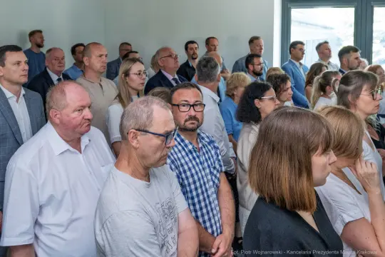 Grupa ludzi w sali, skupionych na wydarzeniu.