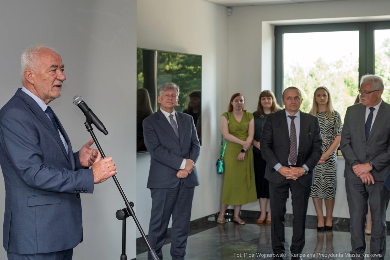 Mężczyzna przemawia do zgromadzonej grupy ludzi w eleganckim wnętrzu.  Autor: Piotr Wojnarowski