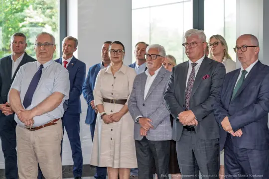 Grupa ludzi w formalnych strojach podczas wydarzenia.