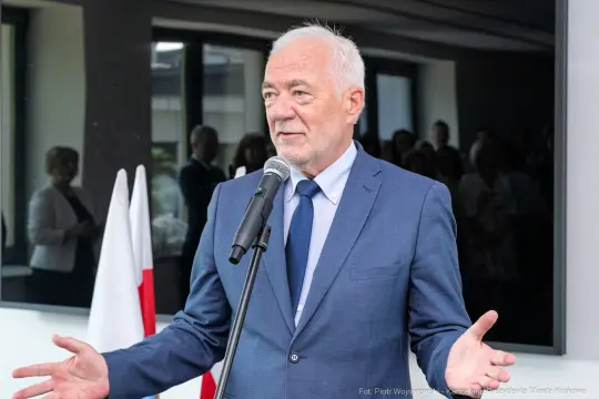 Mężczyzna w garniturze przemawia do zgromadzonej publiczności.