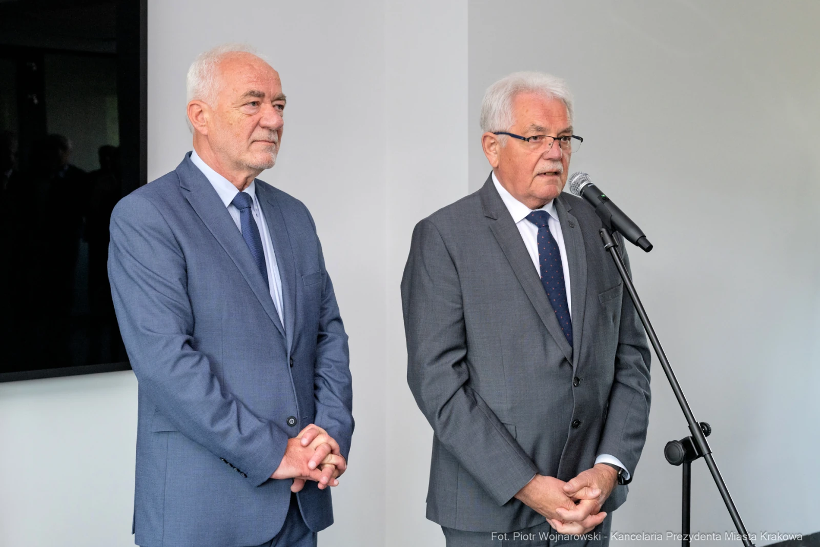 Dwaj mężczyźni w garniturach przemawiają do mikrofonu.  Autor: Piotr Wojnarowski