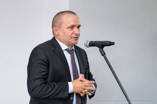 Mężczyzna w garniturze przemawia do mikrofonu.