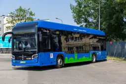Niebieski autobus miejski na parkingu.