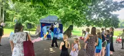 Animacja dla dzieci z klaunem i publicznością w parku.