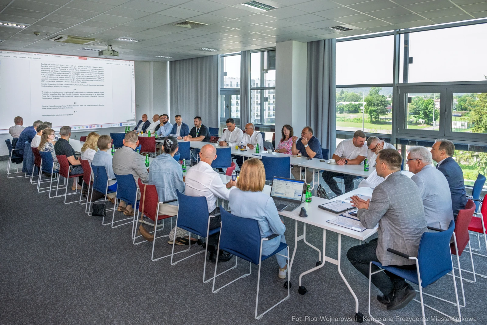 Spotkanie zespołu w sali konferencyjnej, uczestnicy przy stole, prezentacja na ekranie.  Autor: Piotr Wojnarowski